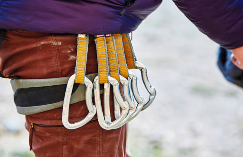 climber with quickdraws on harness